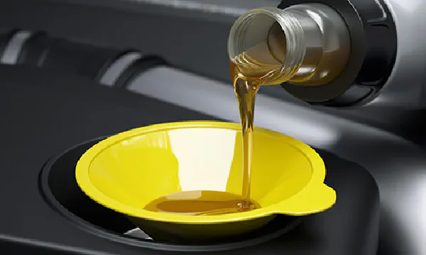 Engine oil pouring through funnel.