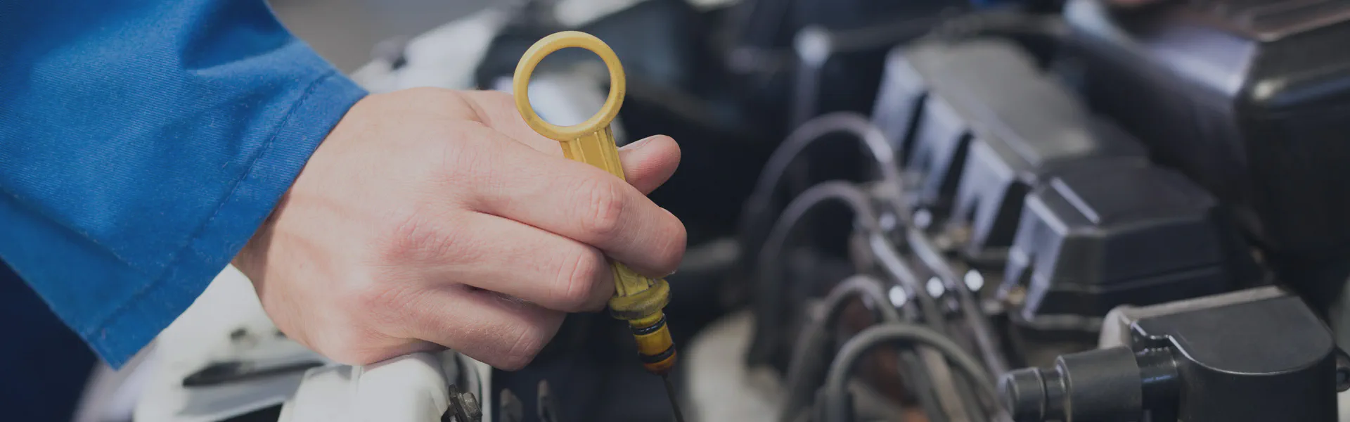 Mechanic checking engine oil dipstick